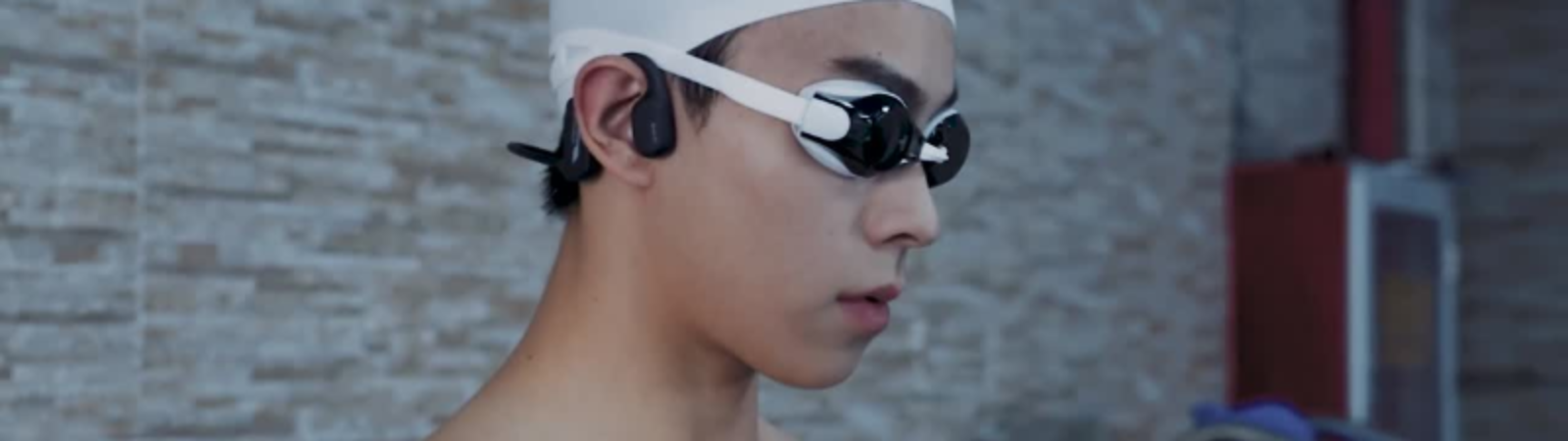 Swimmer wearing waterproof bone conductio headphones open ear f1