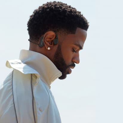Man wearing a white jacket with a clear sky background